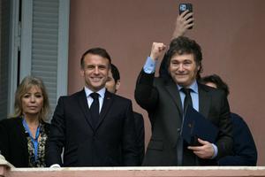 Le président argentin Javier Milei lève le poing aux côtés du président français Emmanuel Macron sur le balcon du palais gouvernemental de la Casa Rosada après une rencontre à Buenos Aires le 17 novembre 2024. 