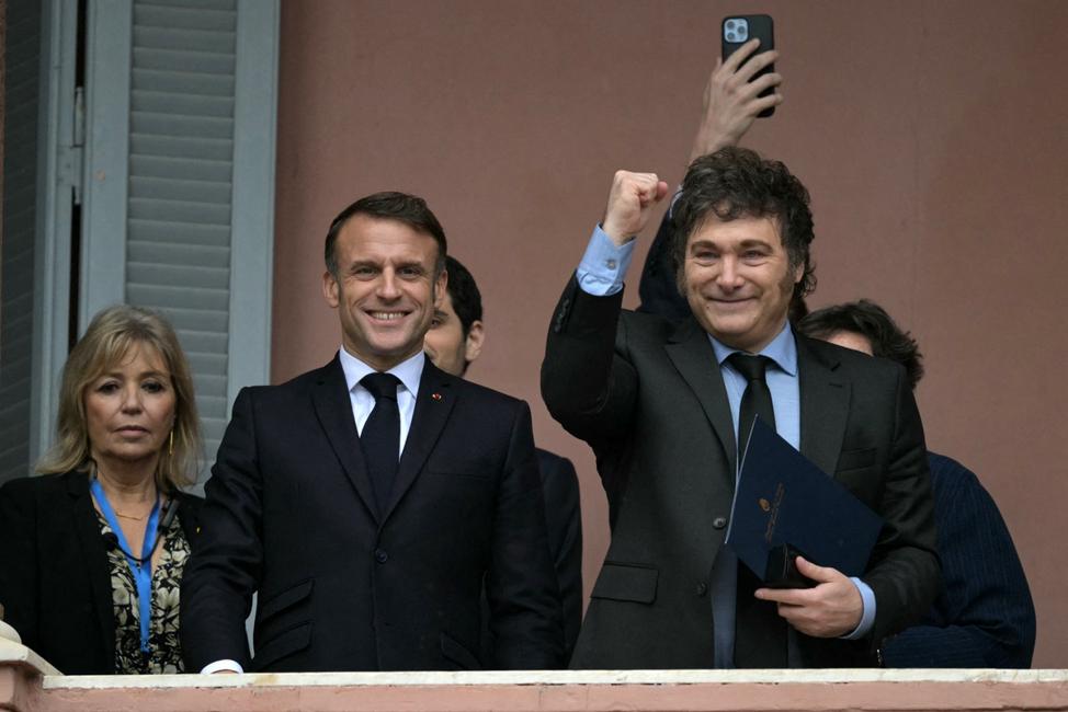 Le président argentin Javier Milei lève le poing aux côtés du président français Emmanuel Macron sur le balcon du palais gouvernemental de la Casa Rosada après une rencontre à Buenos Aires le 17 novembre 2024. 