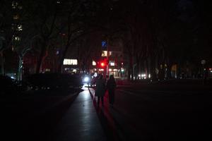 Des habitants marchent de nuit à Barcelone, privés d'électricité, suite à une panne de courant massive qui a touché toute la péninsule Ibérique et le sud de la France, le 28 avril 2025.