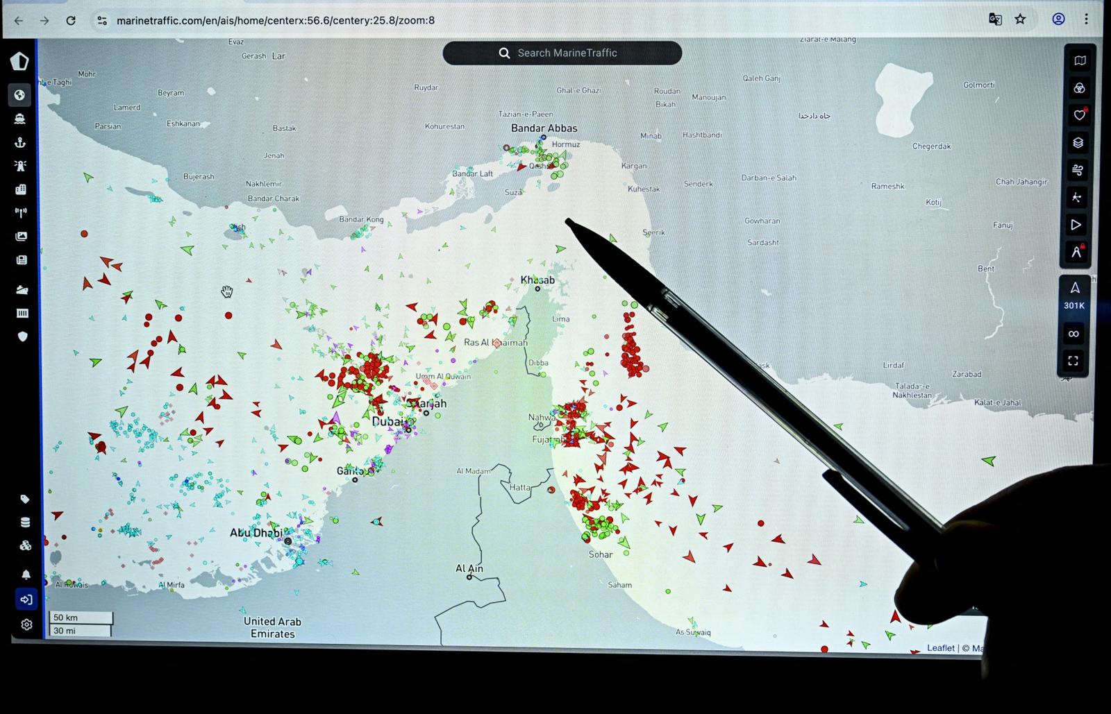 Une personne désigne du doigt une page du site web Marinetraffic qui montre le trafic de bateaux commerciaux à la limite du détroit d'Ormuz, près des côtes iraniennes, le 4 mars 2026.
