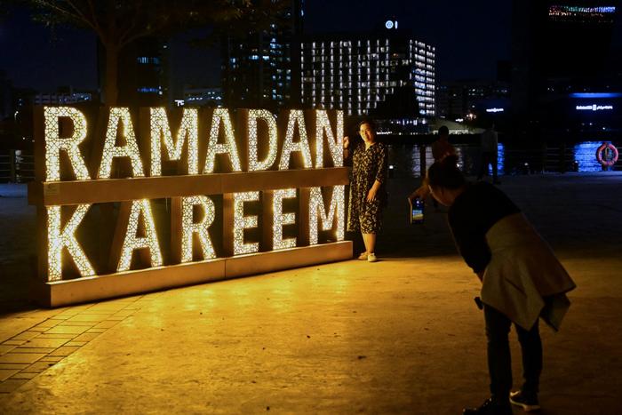 Des femmes prennent des photos à Dubaï le 11 mars 2025, pendant le mois de jeûne musulman du Ramadan.