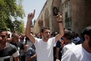 Un jeune Palestinien brandit un Coran, le livre saint de l'islam, lors d'une manifestation contre le balsphème, le 24 juillet 2015, après la prière du vendredi, à la mosquée al-Aqsa, dans la vieille ville de Jérusalem.
