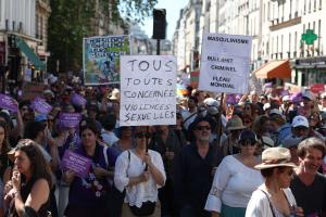 Des manifestants brandissent des pancartes où l'on peut lire « Tous ceux qui sont concernés par les violences sexuelles » (C) et « Le masculinisme, c'est de la foutaise criminelle, un fléau mondial » (R) lors d'un rassemblement contre les violences sexuelles faites aux femmes et aux enfants, organisé par la Fondation des Femmes à Paris, le 4 juillet 2026.