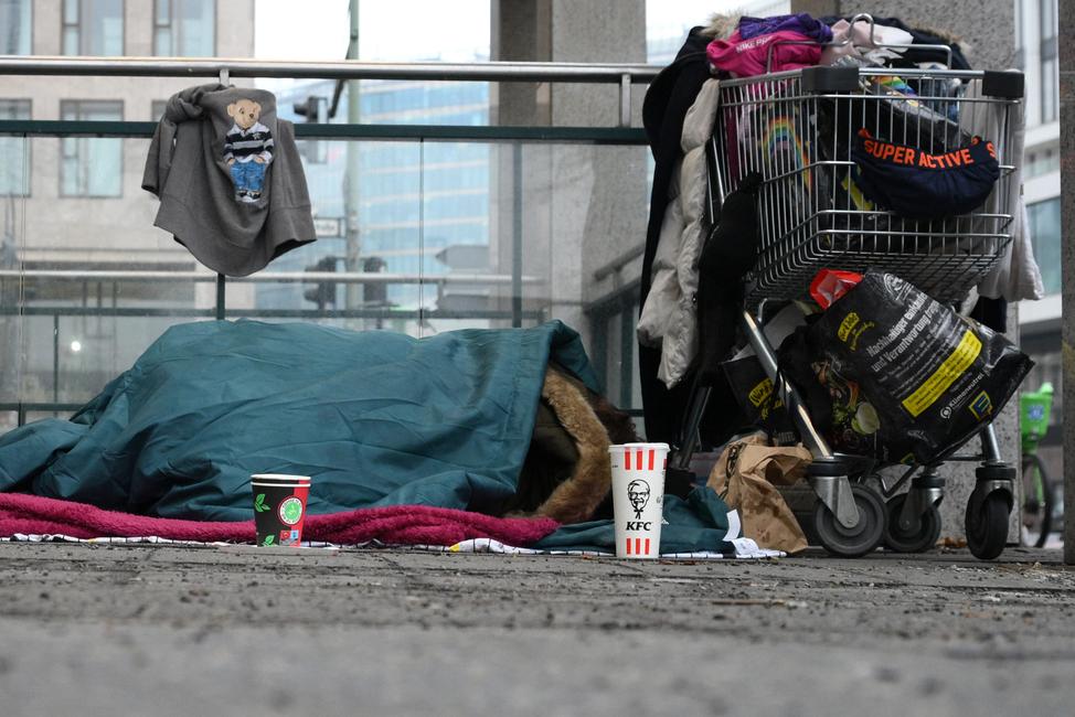 Une personne sans-abri dort sous une couverture sur le trottoir de la gare centrale de Berlin, le 10 février 2026.