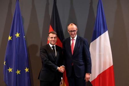 Emmanuel Macron serre la main du chancelier allemand Friedrich Merz, à l'issue d'un sommet sur la souveraineté technologique de l'Europe, le 18 novembre 2025 au campus EUREF de Berlin.