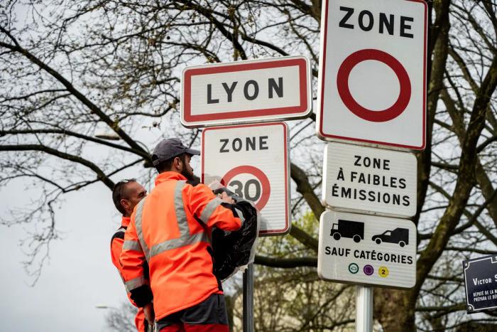Des agents de la ville de Lyon installent un dispositif de limitation de la circulation à 30 km/h.