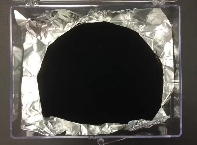 Vantablack sur du papier d'aluminium, illustrant sa capacité à effacer la texture visuelle des objets.