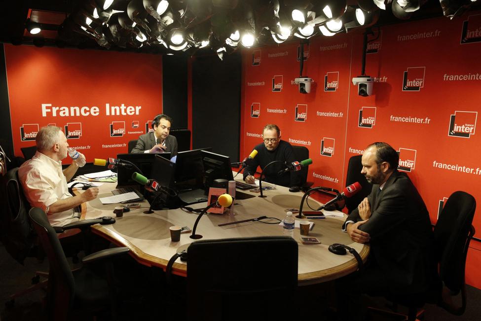 Édouard Philippe (à droite), alors nouvellement Premier Ministre, participe à la matinale de France Inter, avec Patrick Cohen (2e à gauche), journaliste de la station de radio France Inter et le journaliste français Thomas Legrand (2e à droite) à la Maison de la Radio à Paris le 18 mai 2017. (Photo de GEOFFROY VAN DER HASSELT / AFP)