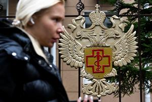 Le 5 octobre 2026, à Moscou, une femme passe devant le logo de Rospotrebnadzor, l'agence russe de surveillance sanitaire et de la consommation, apposé sur la clôture de son enceinte. Le même jour, les autorités russes ont minimisé les informations selon lesquelles un technicien de laboratoire en Sibérie serait décédé de la peste, affirmant que la situation était sous contrôle et que les analyses post-mortem n'avaient révélé aucune trace de la maladie.