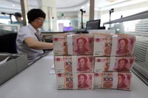 Des billets de banque en renminbi sont placés sur la table d'un employé de banque, dans la province du Jiangsu, dans l'est de la Chine, le 11 août 2015.