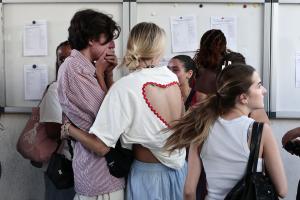 Des lycéens réagissent en consultant leurs résultats du baccalauréat (BAC) sur une liste affichée au lycée Périer de Marseille le 7 juillet 2026.