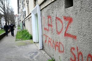 Des policiers patrouillent près d'un panneau faisant référence à la DZ Mafia, tagué sur la façade d'un immeuble dans un quartier d'Avignon, dans le sud de la France.