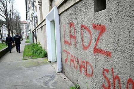 Des policiers patrouillent près d'un panneau faisant référence à la DZ Mafia, tagué sur la façade d'un immeuble dans un quartier d'Avignon, dans le sud de la France.
