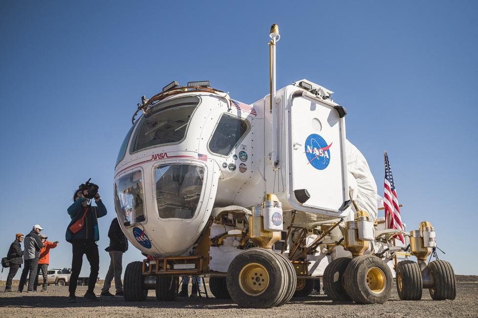 Des journalistes se tiennent à côté d'un prototype de rover lunaire destiné aux futures missions Artemis, sur le site de la coulée de lave de Black Point, près de Flagstaff, en Arizona