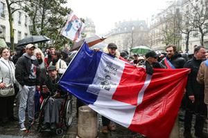Un manifestant brandit un drapeau français sur lequel on peut lire « Justice pour Quentin » lors d'un rassemblement à Paris, le 15 février 2026.