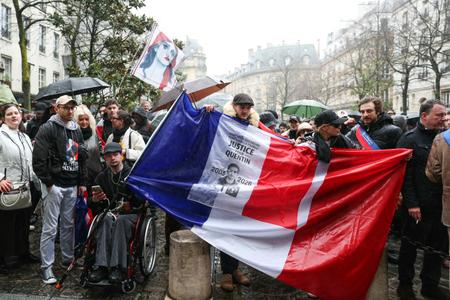 Un manifestant brandit un drapeau français sur lequel on peut lire « Justice pour Quentin » lors d'un rassemblement à Paris, le 15 février 2026.