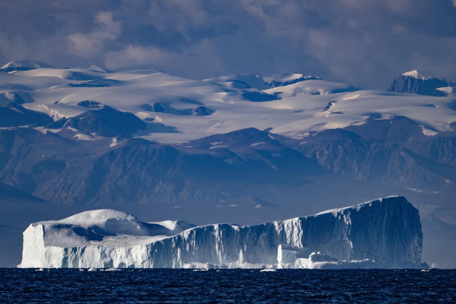 Cette photographie prise le 16 août 2023 montre un iceberg d'environ quelques centaines de mètres de long dérivant le long du fjord Scoresby Sound, à l'est du Groënland.