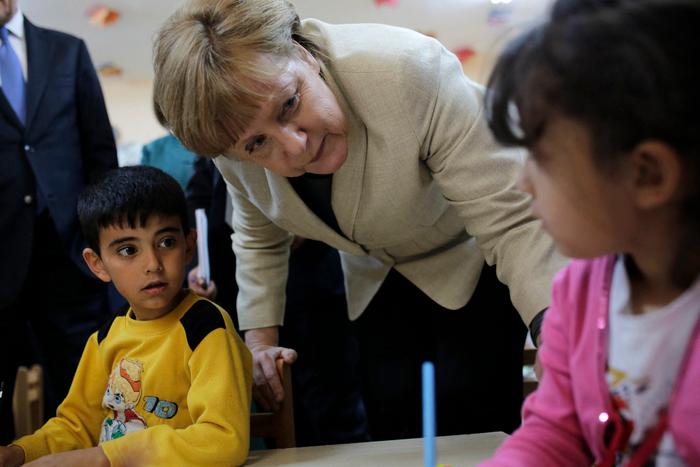 La chancelière allemande Angela Merkel s'entretient avec des enfants réfugiés dans une école maternelle, lors d'une visite dans un camp de réfugiés le 23 avril 2016 à la frontière turco-syrienne, à Gaziantep.