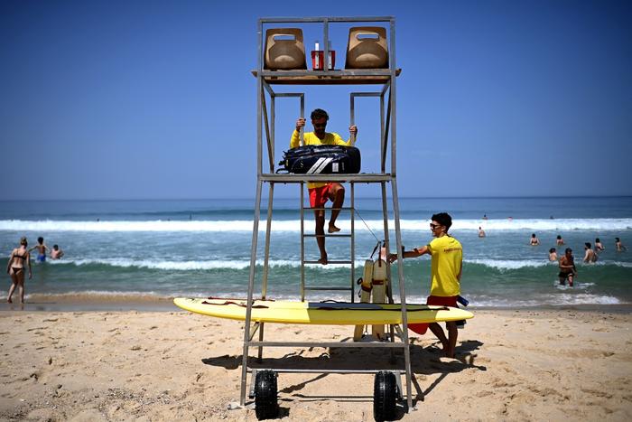 Un maître-nageur arrive pour surveiller baigneurs par une chaude journée le long de l'océan Atlantique à Carcans-plage, dans le sud-ouest de la France, le 20 juin 2025.