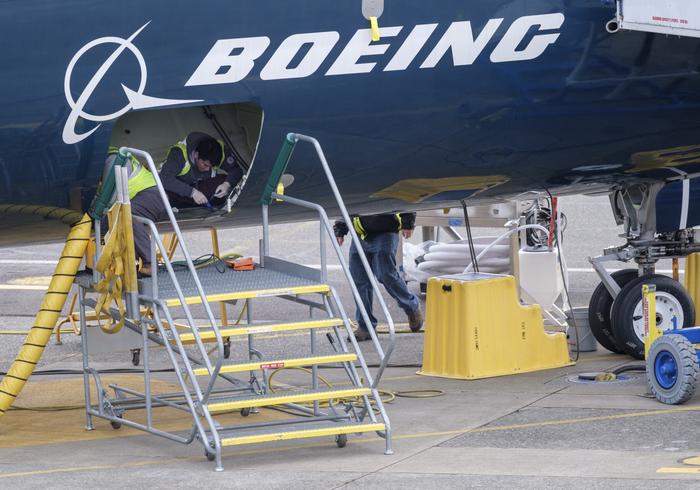 Des employés travaillent dans la soute d'un Boeing 727 MAX 9 d'essai devant l'usine de l'entreprise, le 14 mars 2019 à Renton, Washington.