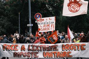 Des manifestants se tiennent derrière une banderole sur laquelle on peut lire : « Face à l’extrême droite, riposte unie », en soutien au groupe antifasciste La Jeune Garde, visé par une procédure de dissolution engagée par le ministre français de l’Intérieur, près de la préfecture du Rhône à Lyon, le 6 mai 2025. Le Conseil des ministres français a annoncé, le 12 juin 2025, la dissolution du mouvement antifasciste La Jeune Garde, ainsi que celle du groupe d’extrême droite Lyon Populaire.