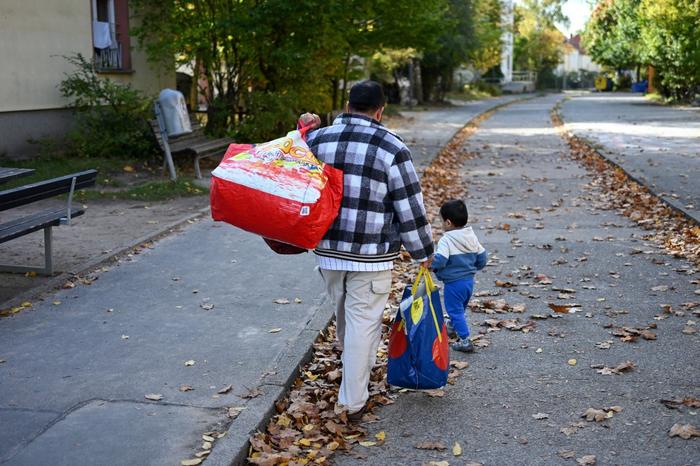 Un homme et son enfant marchent sur le site de l'ancien camp d'accueil d'urgence pour réfugiés et personnes déplacées de RDA, aujourd'hui lieu d'accueil temporaire pour réfugiés syriens, afghans et d'autres pays, à Berlin-Marienfelde, le 16 octobre 2024.