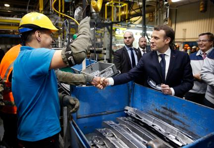 Le président français Emmanuel Macron serre la main d'un employé lors de sa visite de l'usine automobile Toyota à Onnaing, dans le nord de la France, le 22 janvier 2018.