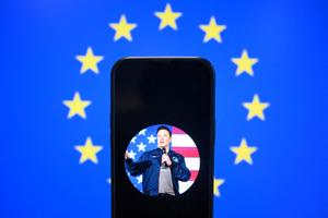 Le compte X (anciennement Twitter) d'Elon Musk affiché sur un smartphone devant un drapeau de l'Union européenne à Bruxelles, le 7 janvier 2025. 