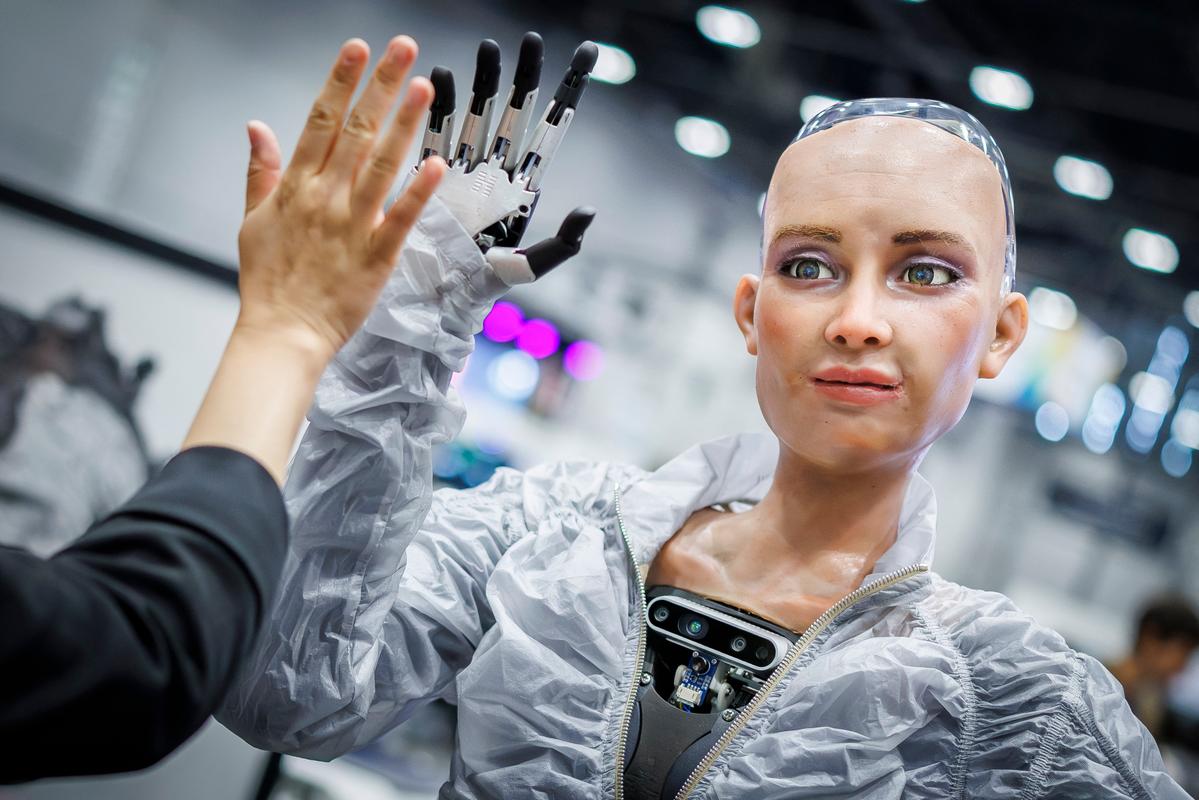 Sophie, un robot utilisant l'intelligence artificielle de Hanson Robotics, échange avec un visiteur lors du Sommet mondial AI for Good de l'Union internationale des télécommunications (UIT) à Genève, le 8 juillet 2025.
