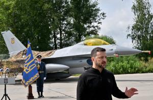 Le président ukrainien Volodymyr Zelensky devant un avion de chasse F16 américain, dans un lieu tenu secret, le 4 août 2024.