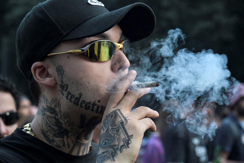 Un homme fume un joint lors d'une manifestation réclamant la légalisation de la marijuana sur l'avenue Paulista, à São Paulo (Brésil), le 16 juin 2024.
