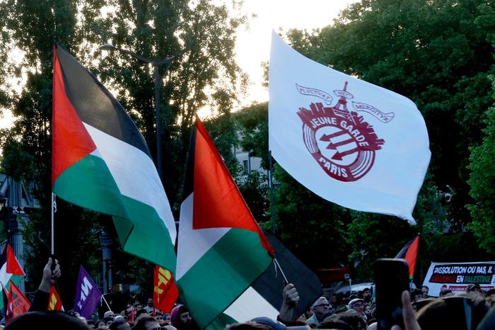 Des manifestants brandissent des drapeaux palestiniens et un drapeau du groupe antifasciste « Jeune Garde » lors d'une manifestation contre la décision du ministre de l'Intérieur de dissoudre « Jeune Garde » et le collectif « Urgence Palestine », place Stalingrad à Paris le 6 mai 2025.
