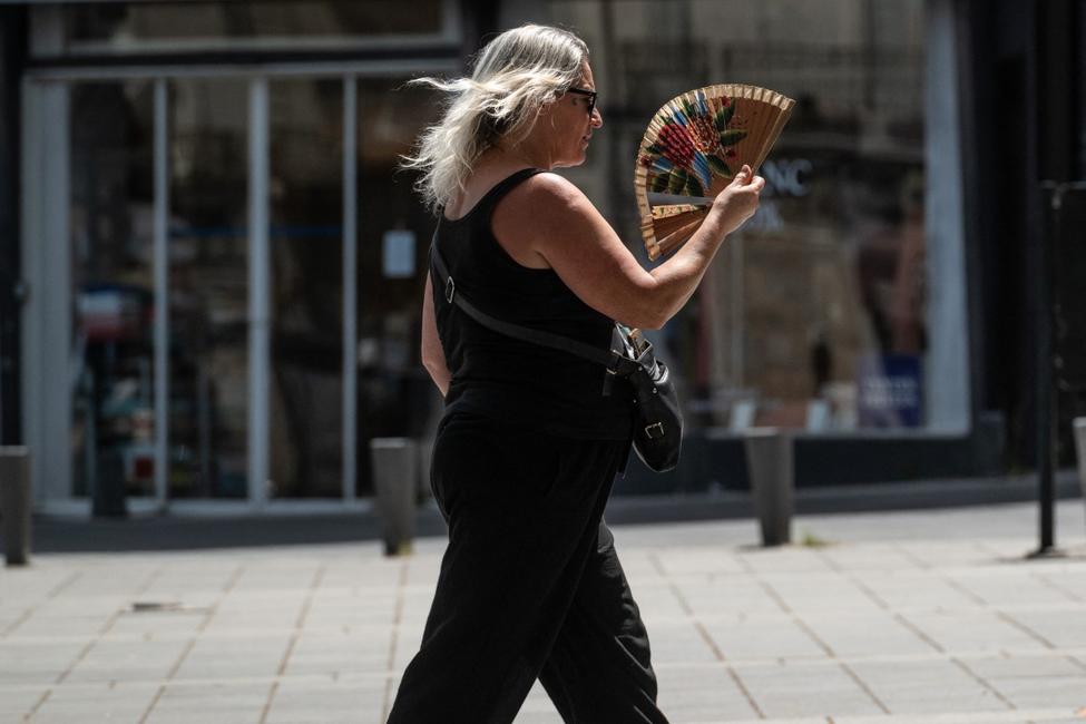 Une femme marche avec un éventail pendant une vague de chaleur à Nantes, dans l'ouest de la France, le 23 juin 2026.