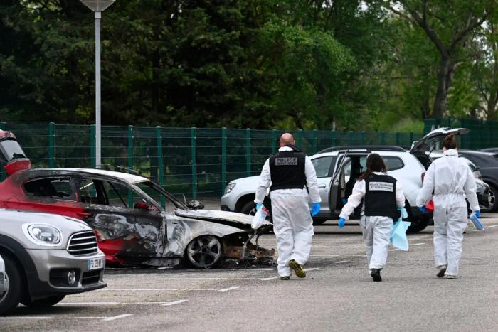 Des policiers de la police scientifique arrivent à proximité d'une voiture incendiée devant la maison d'arrêt de Tarascon, le 16 avril 2025, après que 3 voitures ont été incendiées la nuit précédente sur son parking.