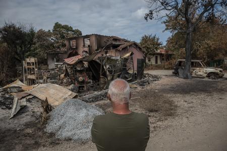 Un homme se tient devant sa maison détruite par un incendie, dans le village du Porge, dans le sud-ouest de la France, le 31 juillet 2026.