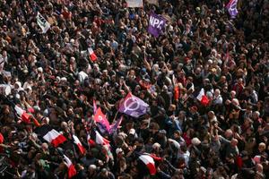 Des manifestants brandissent des drapeaux du Nouveau Parti Anticapitaliste (NPA) et de La France Insoumise (LFI) lors d'un rassemblement contre le racisme devant la mairie de Saint-Denis, en banlieue parisienne, le 4 avril 2026.