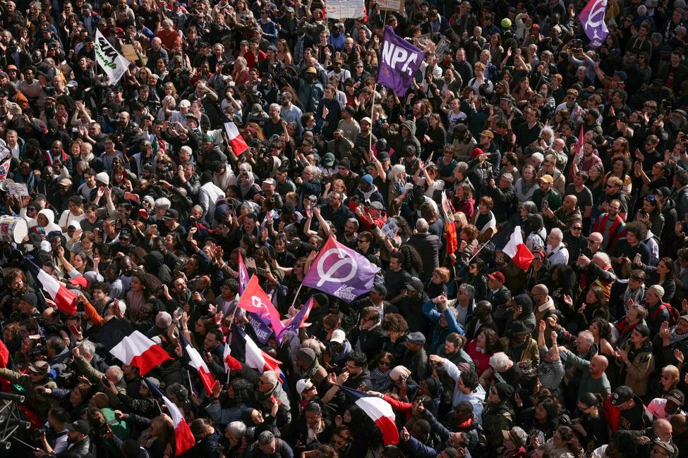 Des manifestants brandissent des drapeaux du Nouveau Parti Anticapitaliste (NPA) et de La France Insoumise (LFI) lors d'un rassemblement contre le racisme devant la mairie de Saint-Denis, en banlieue parisienne, le 4 avril 2026.