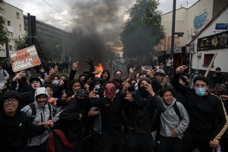 Des lycéens devant un feu qui brûle en arrière-plan, lors d'une manifestation près du lycée Déodat à Toulouse, dans le sud-ouest de la France, le 1er octobre 2026.