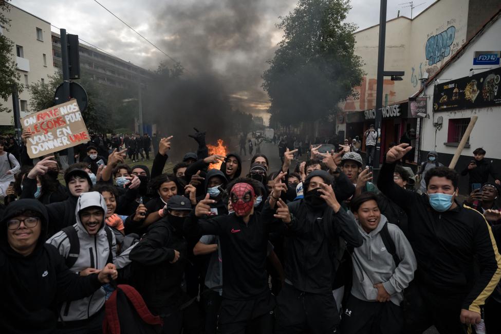 Des lycéens devant un feu qui brûle en arrière-plan, lors d'une manifestation près du lycée Déodat à Toulouse, dans le sud-ouest de la France, le 1er octobre 2026.