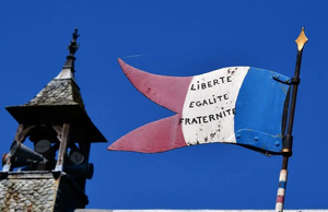 Une pancarte reprenant l'image du drapeau français avec la devise liberté, égalité, fraternité. 
