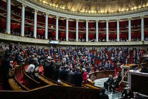 Des députés et des membres du gouvernement français se lèvent pour rendre hommage à Mehdi Kessaci, le frère cadet de 20 ans de l’activiste, membre des Verts et figure de la lutte antidrogue Amine Kessaci, à Marseille, lors d’une séance de questions au gouvernement à l’Assemblée nationale, à Paris, le 18 novembre 2025.