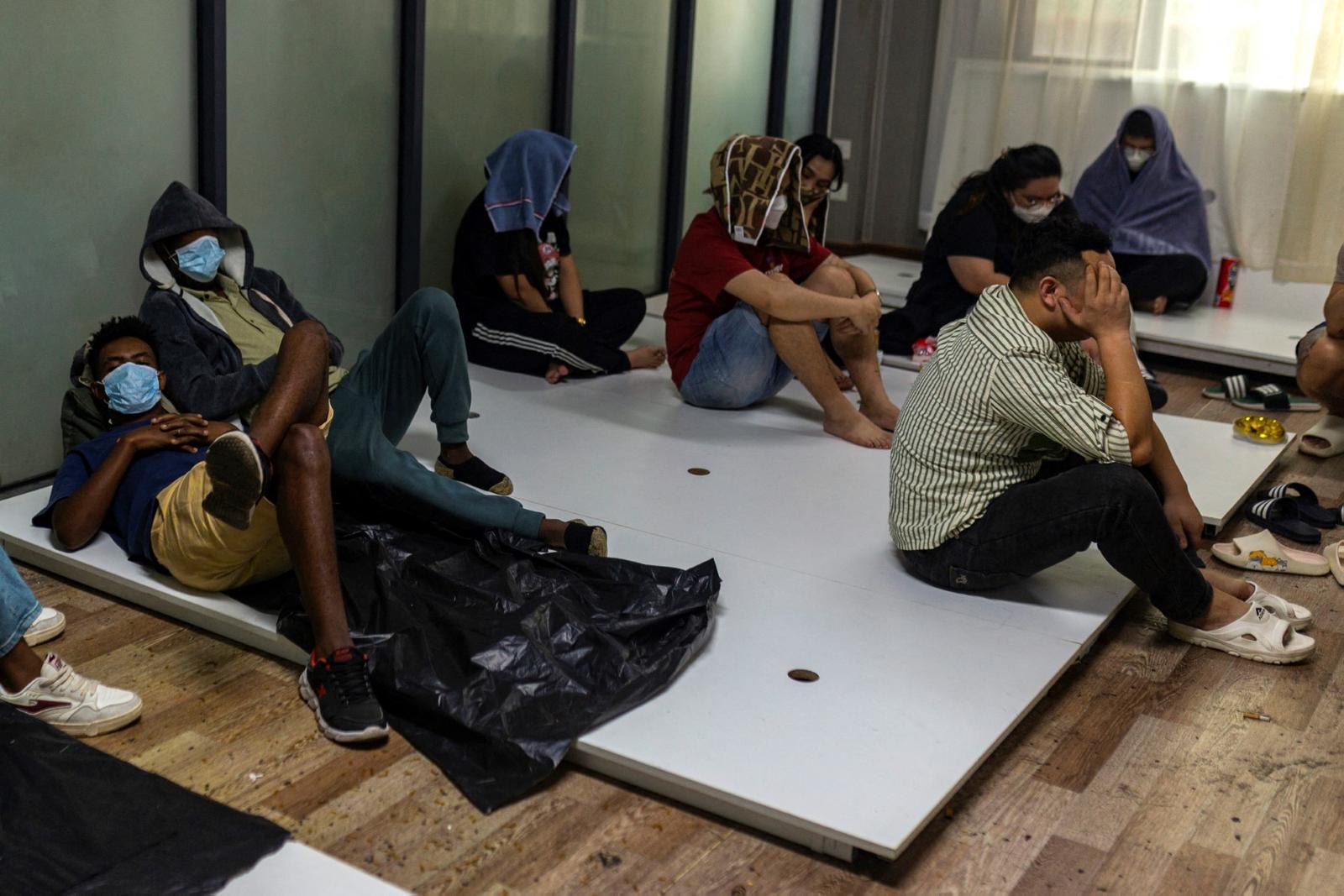 Des employés présumés de centres d'escroquerie et leurs victimes se reposent lors d'une opération de répression menée par la Force de garde-frontières karen (BGF) contre les activités illicites à Shwe Kokko, dans le canton de Myawaddy, à l'est du Myanmar, le 18 février 2025.