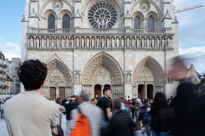 Des fidèles marchent devant la cathédrale Notre-Dame de Paris avant une messe en l'honneur du pape nouvellement élu Léon XIV, dans le centre de Paris, le 9 mai 2025.