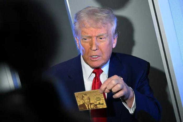 Le président américain Donald Trump montre la Gold Card à des journalistes alors qu'il est en vol à bord de l'Air Force One, le 3 avril 2025.