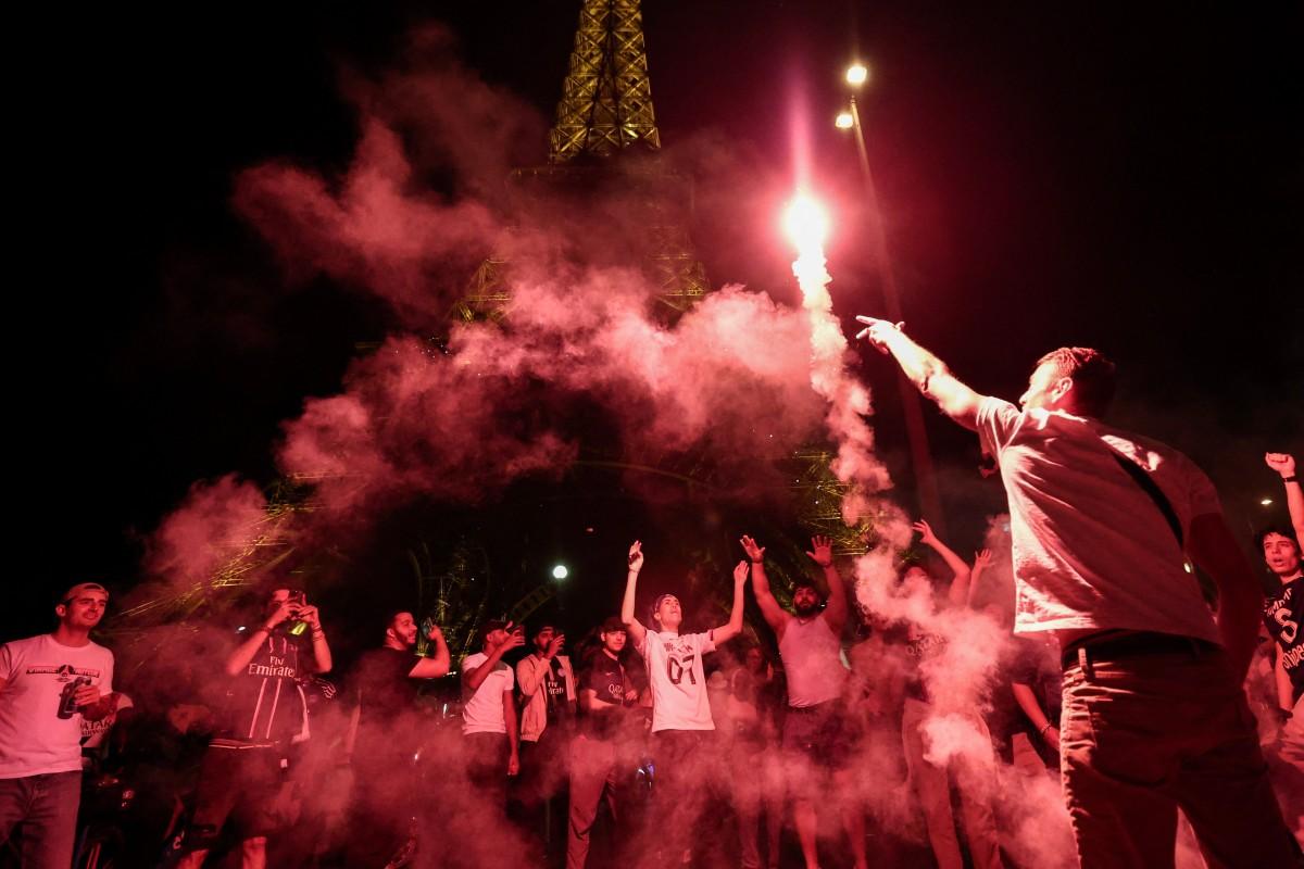 105 / 5 000
Les supporters du Paris Saint-Germain allument des fumigènes devant la Tour Eiffel à Paris, le 31 mai 2025