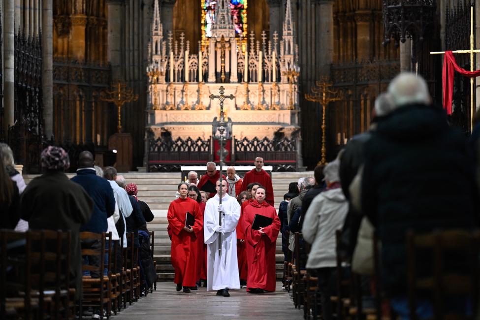 Un prêtre porte un crucifix après la messe du Chemin de Croix, célébrée le Vendredi Saint, en la cathédrale Saint-Étienne de Metz, dans le nord-est de la France, le 18 avril 2025.