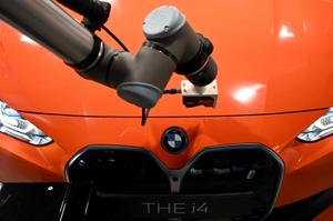 Un robot prend en charge le contrôle qualité d'une nouvelle BMW i4 présentée lors d'un événement marquant le 100e anniversaire de l'usine BMW de Munich, dans le sud de l'Allemagne, le 20 mai 2022.
