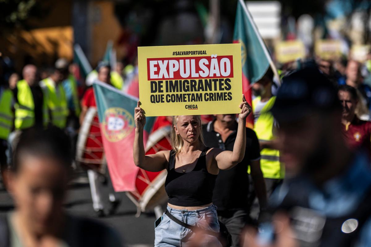 Une femme tient une affiche sur laquelle on peut lire « Expulsion des immigrés auteurs de délits » lors d'une manifestation contre « l'immigration incontrôlée » organisée par Chega à Lisbonne, le 29 septembre 2024.