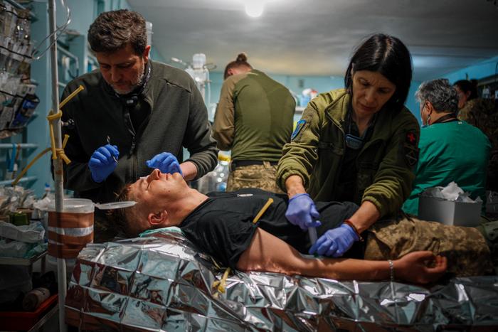 Des médecins militaires prodiguent les premiers soins à un soldat ukrainien blessé dans un poste de stabilisation médicale de première ligne près de la ville de Bakhmut, dans la région de Donetsk, le 4 mai 2023.