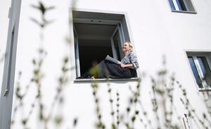 La soprano allemande Lilli Wuenscher, membre de la troupe de l'Opéra de Leipzig, à la fenêtre de sa maison, où elle est confinée avec sa famille en raison de la pandémie de Covid-19, le 3 avril 2020, dans la banlieue de Leipzig, en Allemagne de l'Est.